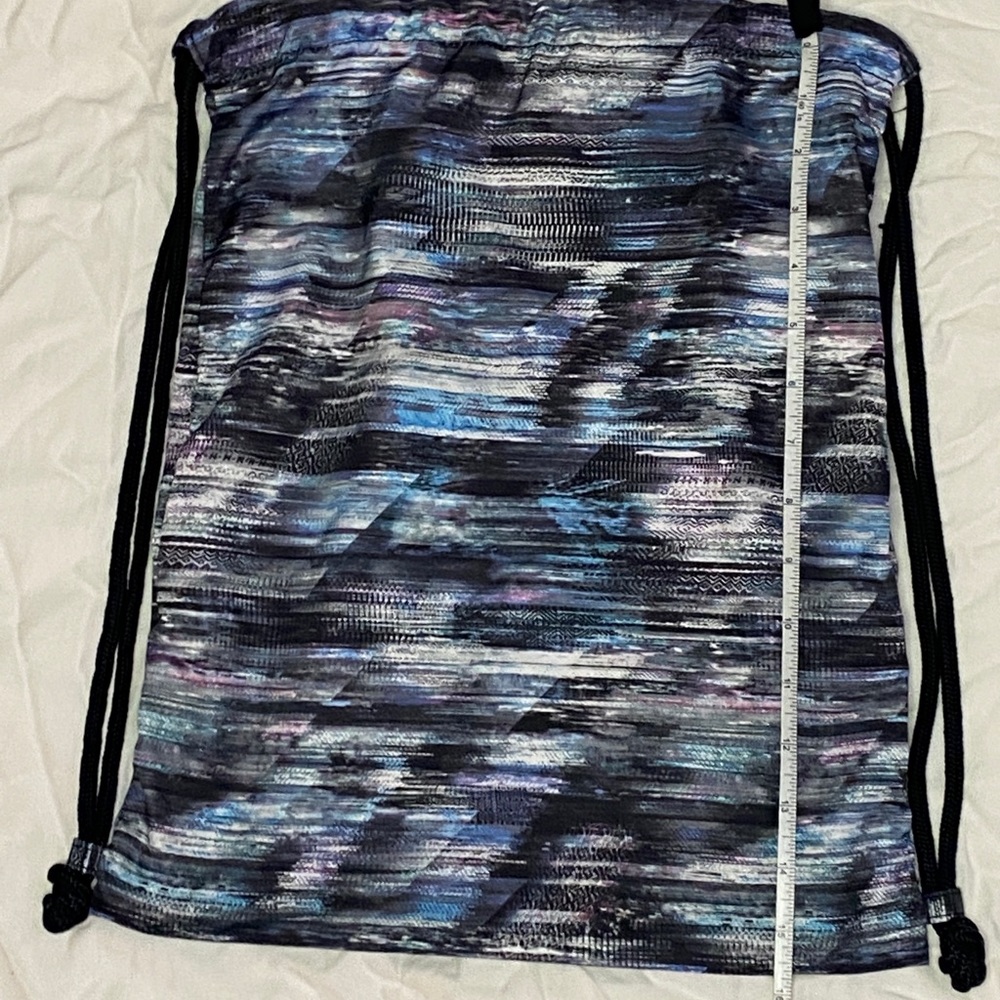 Drawstring bag from ivivva Lululemon that is black, white, purple and blue.